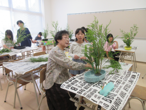 講師先生に生けたお花の手直しをしてもらう受講生