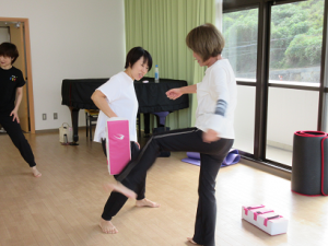 おっかなびっくりで、パッドに向かって左足をあげ、蹴りを体験する受講生