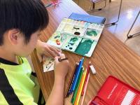 秋の写生大会で使ったパレットを描く子供の様子