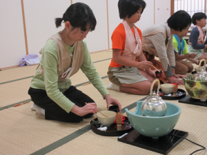 頭の中で作法を思い浮かべながら茶杓でお抹茶を入れる子ども達