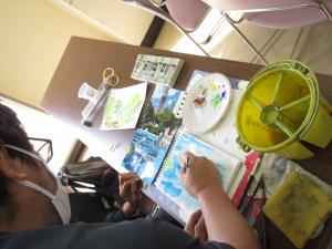 生徒の絵にアドバイスをする先生の写真