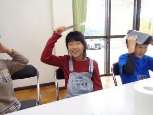 下敷きをこすって髪の毛を逆立てる女の子