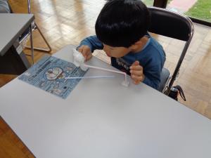 ティシュを近づけて引き付ける力を確認する男の子