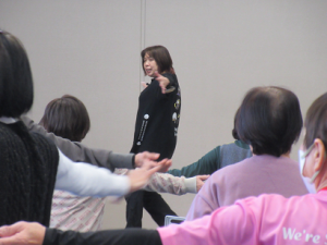 両手を肩の高さで横に広げ、今日の動きの見本を見せる深澤先生