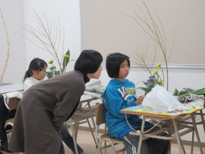 活けた花を前に子ども声をかける講師先生