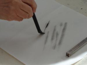 筆先をねじって割筆の稽古の様子