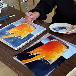 オレンジジュースの絵を描く受講者