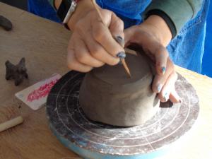 作品の裏に自分の名前番号を彫り込む様子