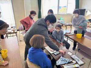 先生の周りに集まって手本を見る受講生の写真