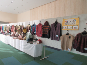 所狭しと展示されているセーター、ベストなどの作品の写真