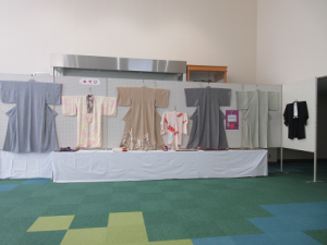 市民会館ホワイエに大小着物が６枚展示されている様子