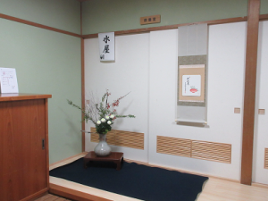 お客様を迎える会場入口には生け花と掛け軸が飾られている