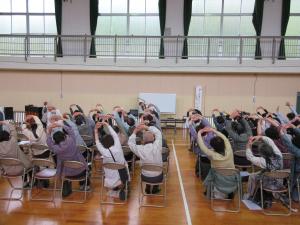 両手を頭の上で組み、体を左横に倒すストレッチをする受講者の様子