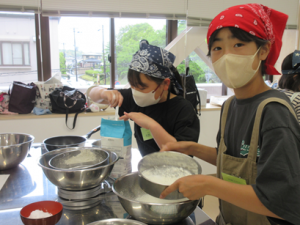 小麦粉等をふるいにかけて生地作りをしている受講生