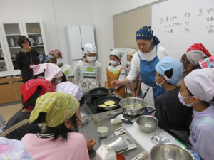 子ども達に焼き方のコツを実演する講師先生