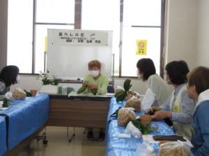 ランの植替え時のポイントを説明する菅野先生と受講生の様子