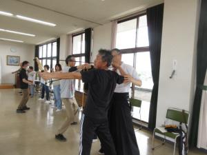 弓を引く形の練習をする受講生とアドバイスをする講師