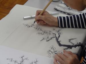 枝先に梅の花を描く様子