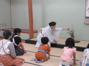 床に飾られた季節の草木の説明をする講師先生