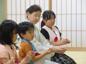 講師先生からお菓子の食べ方の作法を聞く子ども達