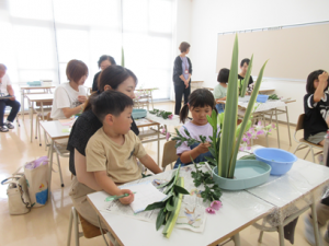 付き添いのお母さんと相談しながら花を生ける受講生