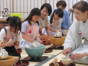 講師の手本を見ながらお茶を立てる受講生の子ども達