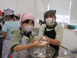 たまたま同じペアーになった二人で団子づくりをする受講生の子ども達