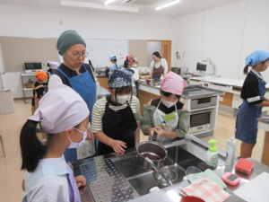 美味しゅうなあれと呪文をかけながら小豆を茹でる受講生の子ども達