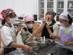 大きな口を開けて味見をする受講生の子ども