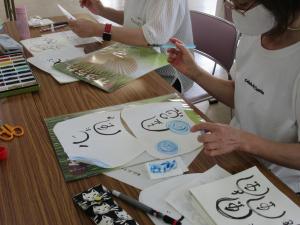和紙に水ペンを使って水色の渦を書いて夏らしさを表現している様子