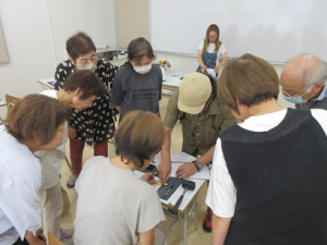 一人の方の作品を手に取り受講生全員に縫い方のコツを説明する講師先生