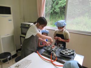 焼きあがったマフィンを冷ますために焼き型から取り出し網の上にのせている様子