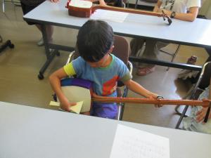 楽譜を見ながら、ひとりで三味線の練習をしている様子