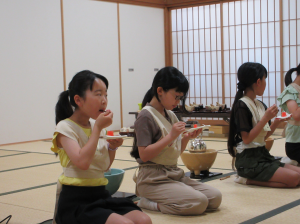 甘いお菓子を頬張り笑顔を見せる受講生の子ども達