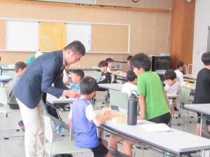 対局する子どもたちに笑顔でアドバイスをする園田先生