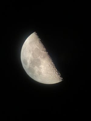 望遠鏡を通してスマートフォンで撮影した月の写真