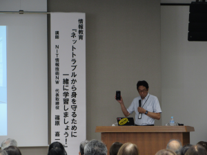 スマホを手に設定について説明をする講師先生