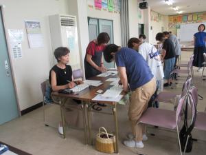 椅子から立って力強い線を書く練習している様子