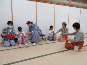 袱紗の使い方をマンツーマンで教えてもらっている子ども達
