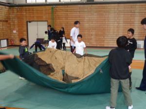 みんなで協力してテントを組み立てる男子グループ