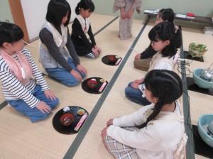 ペアーでお菓子の運び方を練習する受講生の子ども達