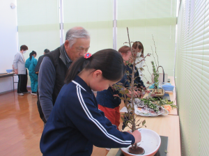 講師に見れいただきながら、剣山に花材を生ける受講生