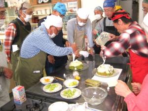 受講生が集まってケーキに生クリームを塗っている様子