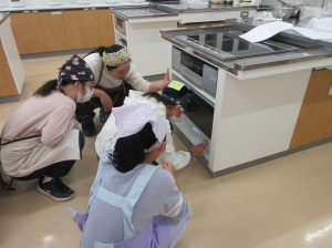 オーブンの中を扉越しに見つめフォカッチャの膨らみ具合を確かめる受講生の子ども達