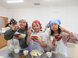 沢山できたポテトサラダの味見をしながらカメラに向かってピースサインをする子ども達