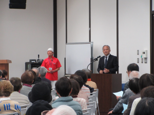 館長が講師紹介している横で音響係を務める講師