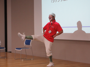 両手を腰に当て軽やかに右足を上げる講師先生