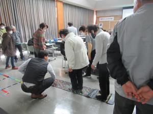 準備されたカラフルな足つぼマットの上を歩いて足裏チェックをする講座生