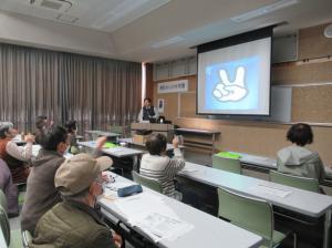 スクリーンに映し出されたぐーちょきぱーで脳トレをする講座生