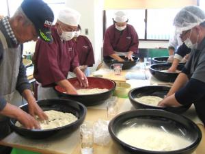 そば粉に水を加えてこねている写真